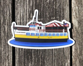 May include: A white and yellow ferry boat with a red and white striped awning. The boat is called "Island Romance" and has an American flag on the back.