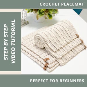 Può includere: Set di sottopiatti all'uncinetto color crema con un design a coste strutturato. I sottopiatti sono impilati e arrotolati, con etichette in pelle attaccate. L'immagine include il testo "CROCHET PLACEMAT", "STEP BY STEP VIDEO TUTORIAL" e "PERFECT FOR BEGINNERS".