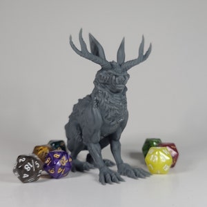 May include: A gray, detailed figurine of a jackalope-like creature with antlers, surrounded by various polyhedral dice. The figurine has a textured surface and is posed in a seated position. The dice are in various colors.