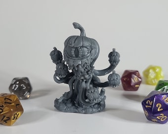 May include: A gray 3D printed pumpkin-shaped creature with multiple tentacles and a single eye. The creature is surrounded by six colorful dice.