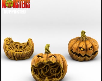 May include: Three orange Halloween pumpkin figurines with carved faces and stems. One pumpkin is split open, revealing the inside. The text "Print Your Monsters Supported" is in the upper left corner.