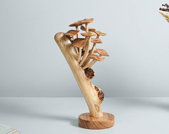 May include: A wooden sculpture of a tree with mushrooms growing on it. The sculpture is made of natural wood and has a rustic look. The mushrooms are carved in detail and have a realistic appearance.