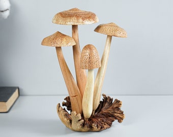 May include: A wooden sculpture of four mushrooms with brown caps and stems. The mushrooms are arranged in a cluster on a base of wood.