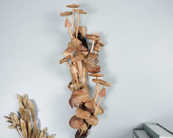 Könnte beinhalten: Eine Wandskulptur aus Holz mit einer Gruppe von geschnitzten Pilzen in Braun- und Beigetönen, die auf einem natürlichen Holzast angeordnet sind.