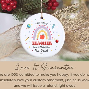 Peut inclure: Ornement en c&eacute;ramique blanc avec un arc-en-ciel, une pomme et des graphiques scolaires. Le texte indique "First Year as Teacher", "Teacher", le nom de l'&eacute;cole et "Mrs. Barret 2025". L'ornement est suspendu &agrave; une ficelle dor&eacute;e.