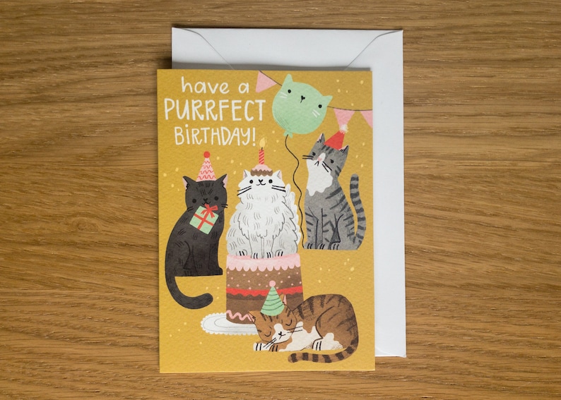 May include: A yellow birthday card with the text "have a purrfect birthday!" and a cartoon illustration of four cats celebrating with a cake and a balloon.