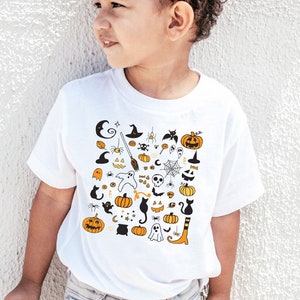 May include: A white t-shirt with a black and orange Halloween-themed print featuring pumpkins, ghosts, bats, spiders, and other spooky icons.