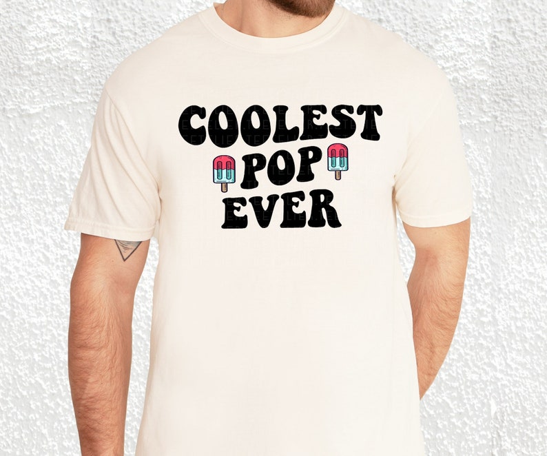 May include: A white t-shirt with black text that reads "Coolest Pop Ever" and two cartoon popsicles.