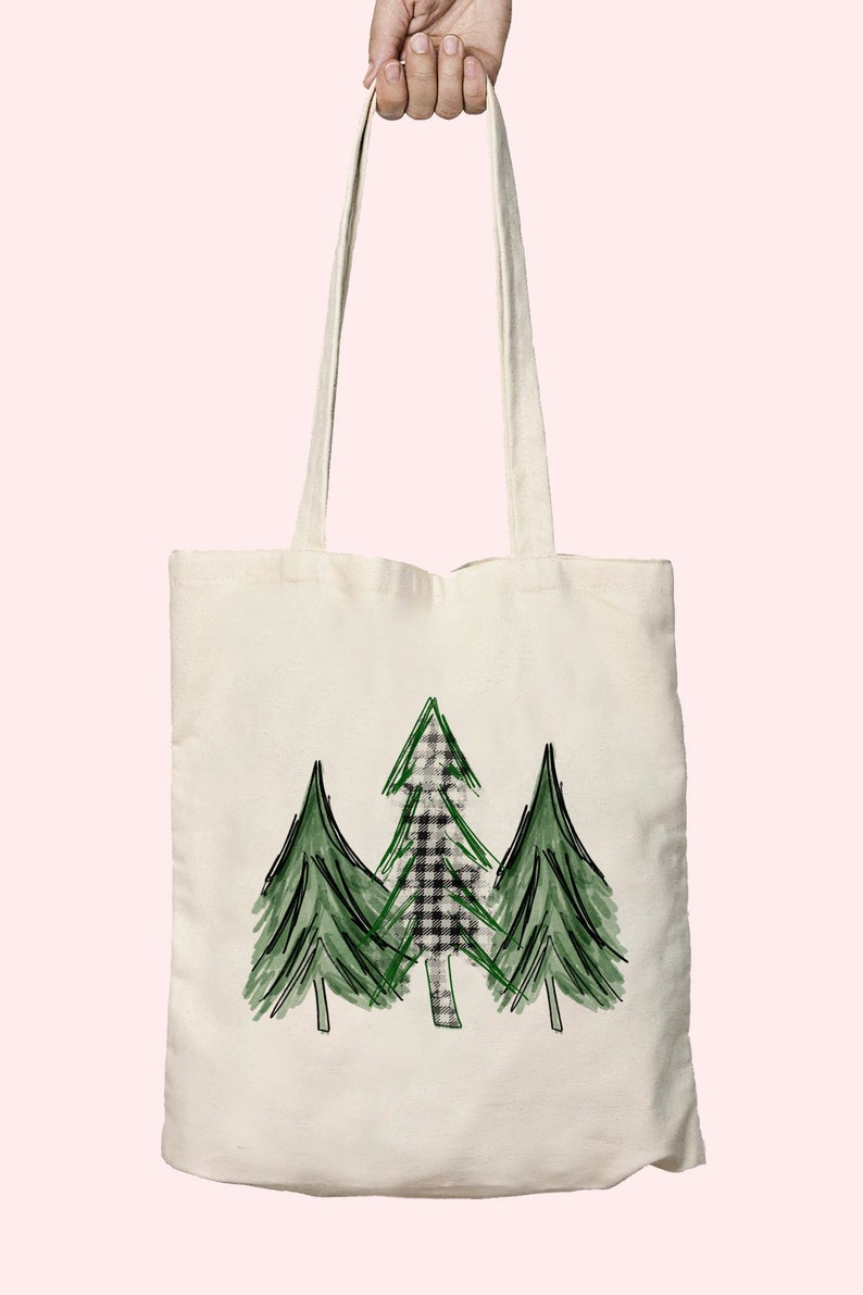 K&ouml;nnte beinhalten: Eine wei&szlig;e Canvas-Tragetasche mit einem Design aus drei gr&uuml;nen B&auml;umen. Der mittlere Baum hat ein schwarz-wei&szlig;es Karomuster.