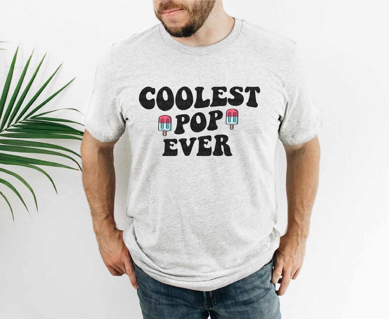 May include: A gray t-shirt with the text "Coolest Pop Ever" in black with two blue and pink popsicle graphics.