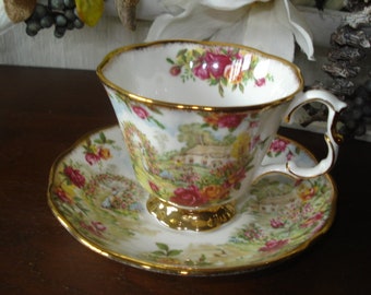 May include: A white teacup and saucer with a floral pattern. The cup has a gold rim and a handle. The saucer has a gold rim and a floral pattern.