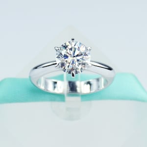 Op de afbeelding: Een zilveren ring met een grote, heldere, ronde diamant.
