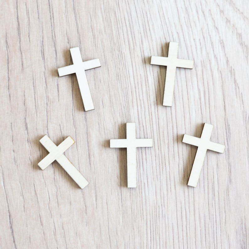 Peut inclure: Cinq croix en bois blanc sur un fond en bois clair. Les croix sont toutes de la m&ecirc;me taille et de la m&ecirc;me forme.