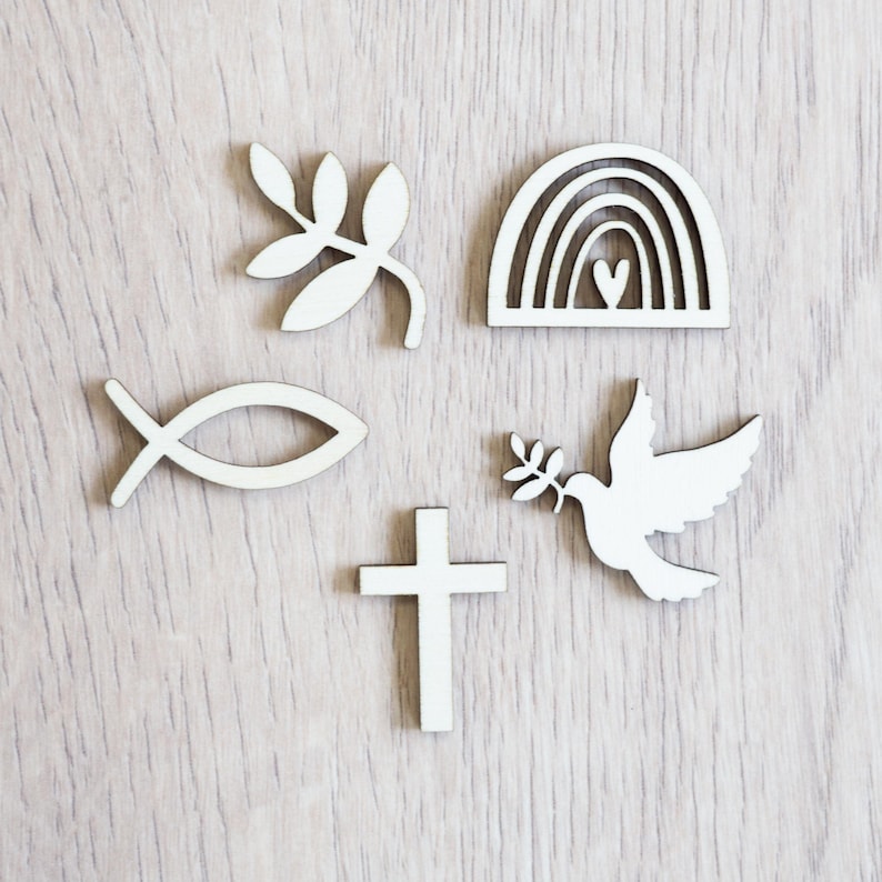Peut inclure: Ensemble de six formes d&eacute;coup&eacute;es en bois blanc, comprenant une croix, une colombe avec une branche d'olivier, un poisson, un arc-en-ciel avec un c&oelig;ur et deux branches de feuilles.