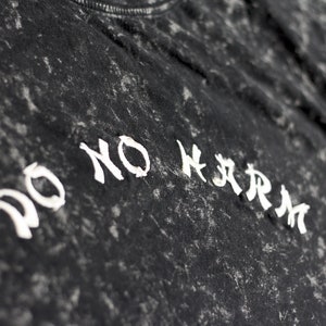 May include: Black t-shirt with a white distressed graphic that says "DO NO HARM".