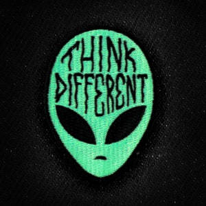 May include: Green alien head patch with the text "Think Different" in black.