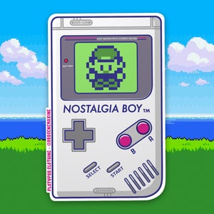 May include: A white and gray handheld video game console with a green screen displaying a pixelated character. The console has a gray plus sign button, two pink buttons labeled "A" and "B", a "SELECT" button, a "START" button, and the text "NOSTALGIA BOY TM".