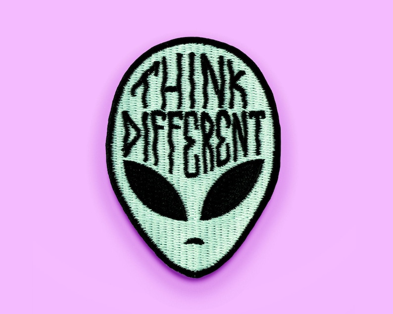 May include: A green alien-shaped patch with black embroidery that reads "Think Different".