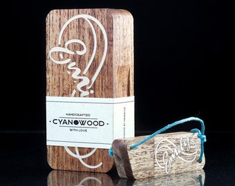 May include: A wooden USB drive with the word "Family" engraved in a cursive font. The drive is attached to a teal blue string. The drive is handcrafted by Cyanwood.