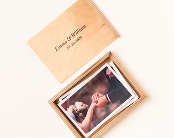 May include: A wooden box with a lid that has the text "Emma & William 29-10-2020" engraved on it. The box contains a photograph of a wedding couple exchanging rings.