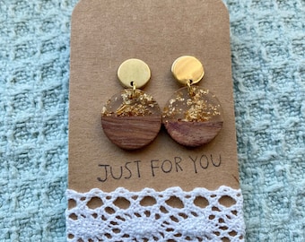 Puede incluir: Un par de pendientes redondos de color dorado y marrón con detalles de pan de oro. Los pendientes están en una tarjeta marrón con ribete de encaje blanco y el texto "JUST FOR YOU".
