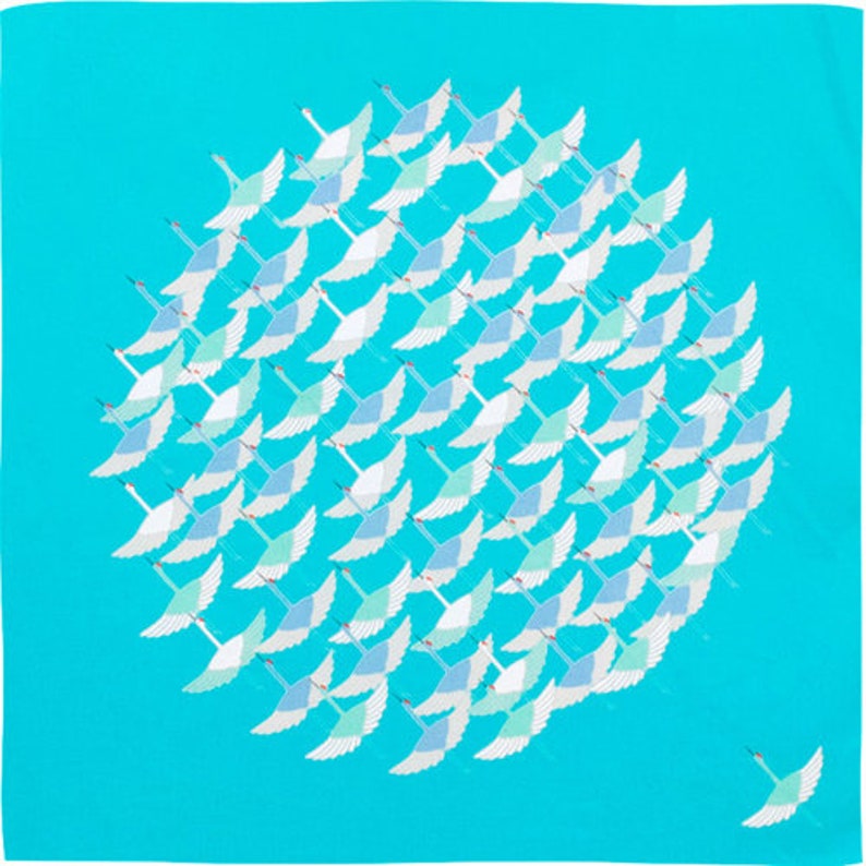May include: A square, turquoise-colored scarf featuring a flock of stylized white and blue birds in flight. The birds are arranged in a circular pattern, with one bird flying solo in the lower right corner. The scarf is made of a soft material.