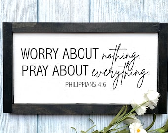 May include: A framed sign with a white background and black text that reads "WORRY ABOUT nothing. PRAY ABOUT everything. Philippians 4:6".