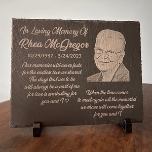 K&ouml;nnte beinhalten: Eine schwarze Schiefertafel mit einem Foto einer Person und einer eingravierten Botschaft. Die Botschaft lautet "In liebevoller Erinnerung an Rhea McGregor 10/29/1937 - 3/24/2023 Unsere Erinnerungen werden nie verblassen f&uuml;r die unendliche Liebe, die wir teilten Die Tage, die fr&uuml;her waren, werden immer ein Teil von mir sein, denn Liebe ist ewig f&uuml;r dich und mich Wenn die Zeit kommt, uns wieder zu treffen, werden all die Erinnerungen, die wir teilen, f&uuml;r dich und mich zusammenkommen".