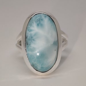 Peut inclure: Une bague en argent avec une grande pierre précieuse ovale bleue et blanche.