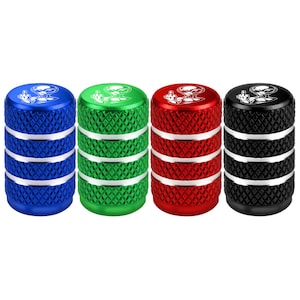 May include: A set of four cylindrical tire valve caps in blue, green, red, and black. Each cap features a textured diamond-patterned grip, two horizontal silver bands, and a white graphic of an alien figure on the top surface.
