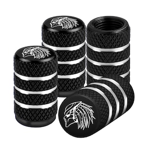 May include: Set of black tire valve stem caps with a diamond pattern and silver accents. Each cap features a white graphic of a Predator alien. The caps are designed to protect the tire valves.