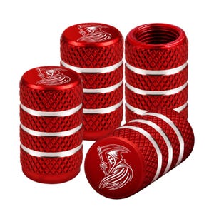 May include: Set of red metal tire valve stem caps. Each cap has a diamond pattern and silver bands. A white graphic of the Grim Reaper is on the top of each cap. The caps are designed to protect the tire valves.