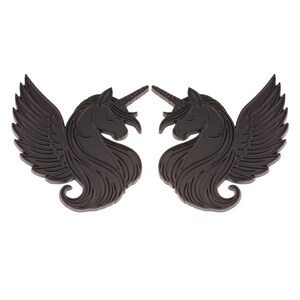 May include: Two dark gray unicorn-pegasus hybrids with closed eyes and detailed wings. The mythical creatures have a horn and flowing mane. The image is a close-up of the two matching figures, set against a white background.