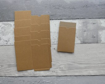 May include: A set of six brown cardboard boxes, each with a flap on the top. The boxes are arranged in a stack, with the largest box on the bottom and the smallest box on top. There is also a single brown cardboard box with a flap on the top.