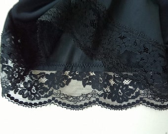May include: Black lace trim with a scalloped edge. The lace is delicate and intricate, with a floral pattern.
