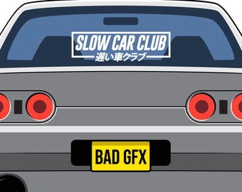 以下が含まれることがあります： 丸い赤いテールライト、BAD GFXと書かれた黄色いナンバープレート、SLOW CAR CLUBの文字と日本語が記されたリアウィンドウステッカーが特徴的な、グレーの車の背面イラスト。