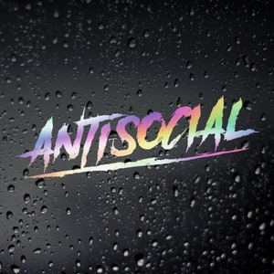 May include: A colourful, rainbow-hued decal with the word "ANTISOCIAL" written in a bold, stylised font. The decal is placed on a black surface with water droplets.