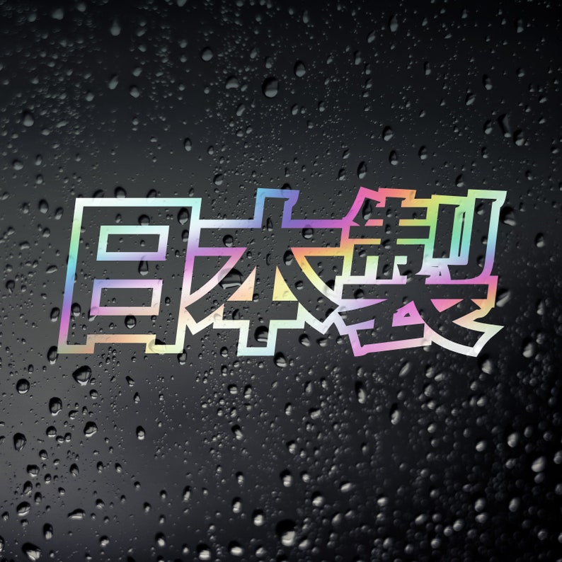 May include: A sticker with the Japanese word "日本製" (Nihonsei), meaning "Made in Japan", in a rainbow gradient color scheme. The sticker is outlined in white and has a slightly pixelated, retro look.