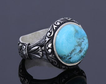 May include: A silver ring with an ornate design and a turquoise stone.