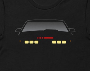 Puede incluir: Camiseta negra con la silueta de un coche con faros y una barra de luz roja. El coche es un modelo popular de la década de 1980.