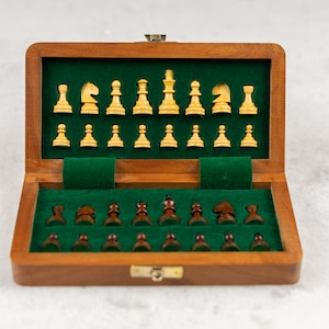 Peut inclure: Un jeu d'échecs en bois avec un intérieur en feutre vert. L'ensemble comprend 16 pièces brun clair et 16 pièces brun foncé.
