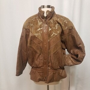 May include: A brown leather jacket with a high collar and a zipper closure. The jacket features a unique design with textured panels and a cinched waist. The sleeves are long and the jacket has a vintage aesthetic.