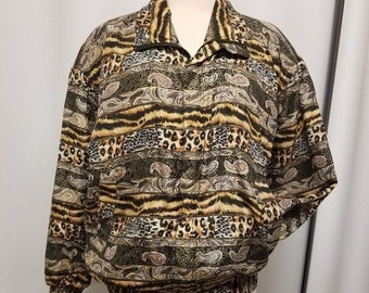 May include: A patterned jacket with a mix of animal prints, including tiger stripes and leopard spots, in shades of brown, tan, and black. The jacket has a collared neckline, a zipper, and a gathered waist and cuffs.