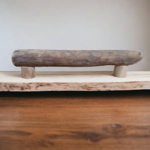 May include: A wooden serving tray with a natural wood finish. The tray has a unique, rustic look and features a natural wood branch handle.