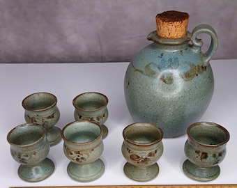 Servizio da tavola vintage Mark Mason Australian Studio Pottery composto da 7 pezzi: brocca smaltata e 6 portauova/calici coordinati, tutti realizzati a mano al tornio.