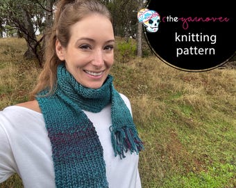Può includere: Una sciarpa lavorata a maglia verde acqua e viola con frange, indossata da una persona. La sciarpa ha un effetto sfumato ed è realizzata con filato spesso. L'immagine include anche il testo "the yarnover knitting pattern".