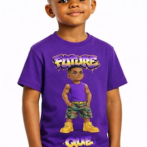 May include: A purple t-shirt with the word "FUTURE" in graffiti-style lettering. The shirt features a cartoon illustration of a young boy wearing a purple tank top, camouflage shorts, and yellow boots. The boy is smiling.