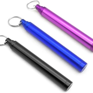 May include: Three keychain-style containers in black, blue, and purple. Each container has a metal loop for attaching to a keychain.