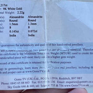 Puede incluir: Un certificado que detalla las especificaciones de una piedra preciosa de Alejandrita. El documento enumera el tipo de metal como oro blanco de 9K, con un peso total de metal de 2,22 gramos. El tama&ntilde;o de la gema es de 1,5 mm y 1,3 mm, con 8 piezas, y el origen es India.