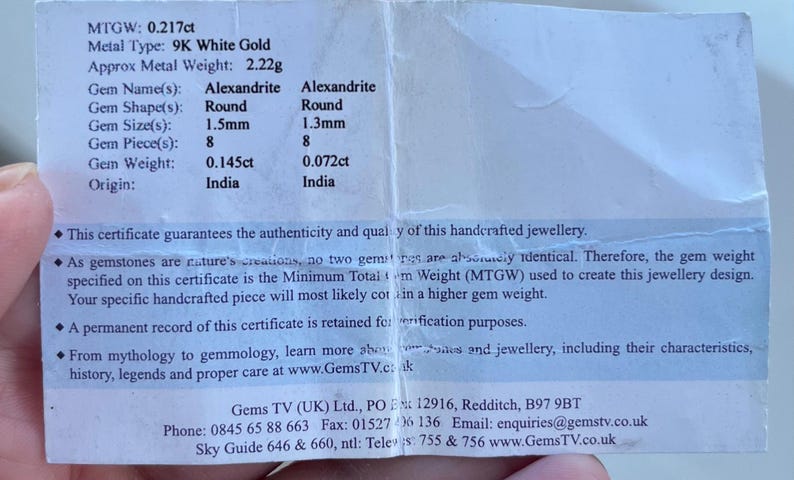 Puede incluir: Un certificado que detalla las especificaciones de una piedra preciosa de Alejandrita. El documento enumera el tipo de metal como oro blanco de 9K, con un peso total de metal de 2,22 gramos. El tama&ntilde;o de la gema es de 1,5 mm y 1,3 mm, con 8 piezas, y el origen es India.